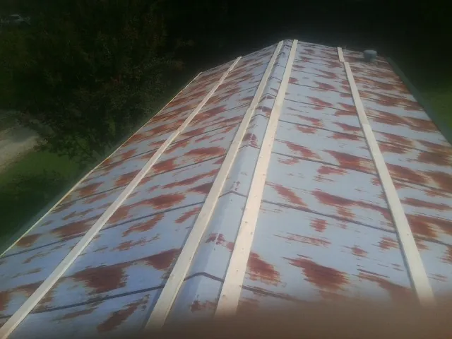 Rusted metal roof panels with new wood purlins before replacement — Storm Damage Roof Repair in Crumpler by Roofing Brothers