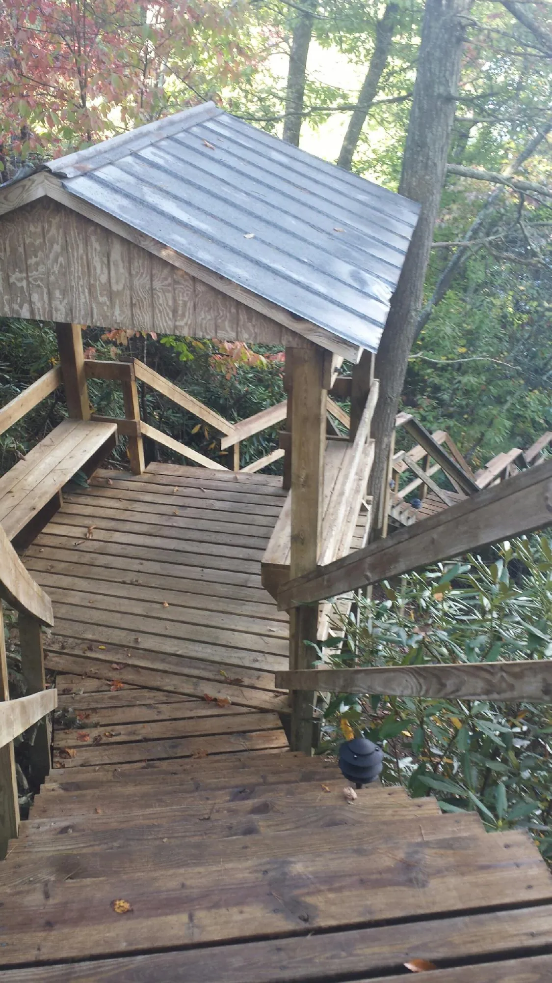 Metal roofed shelter over wooden steps on a wooded walkway — Skylight Repair & Installation work by our crew in Crumpler