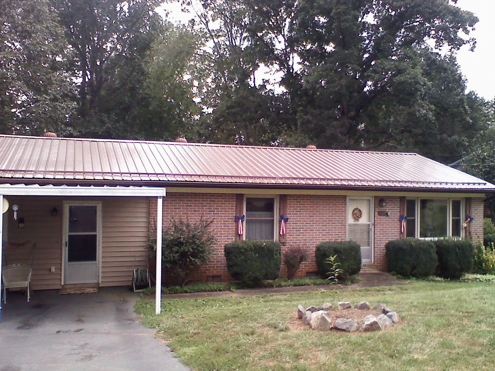 Bronze metal roof and carport on a brick ranch home — Roof Repair work by our crew in Crumpler